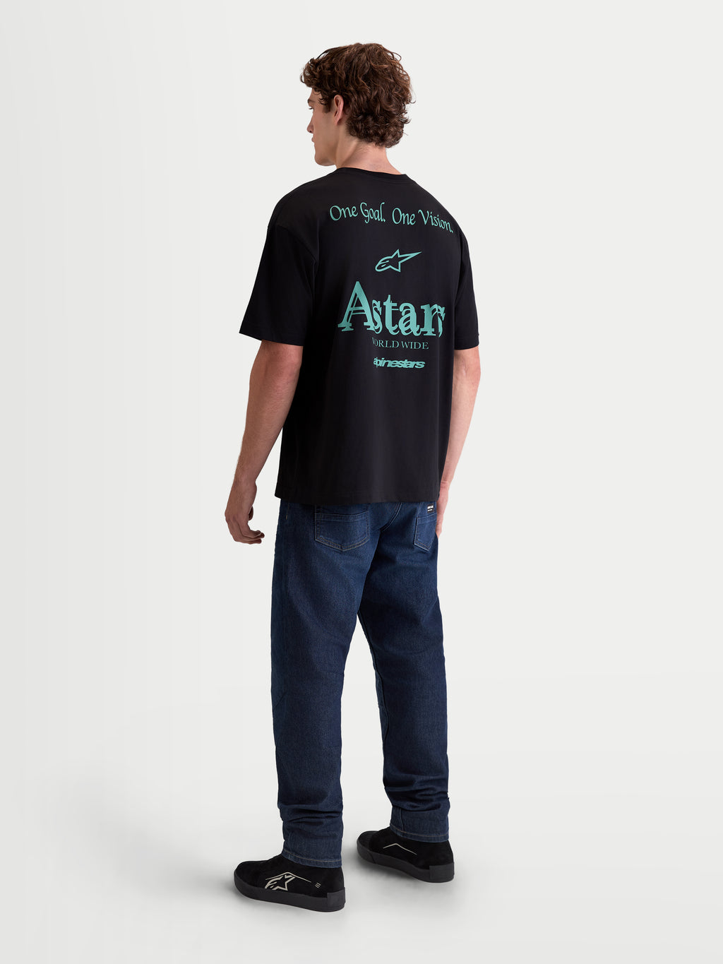 Alpinestars Maglietta Post Oversized CSF, maglietta sportswear da uomo, nera con grafiche verde acqua sulla schiena, vista posteriore su modello, scritte One Goal One Vision e Astars Worldwide, in morbido misto cotone