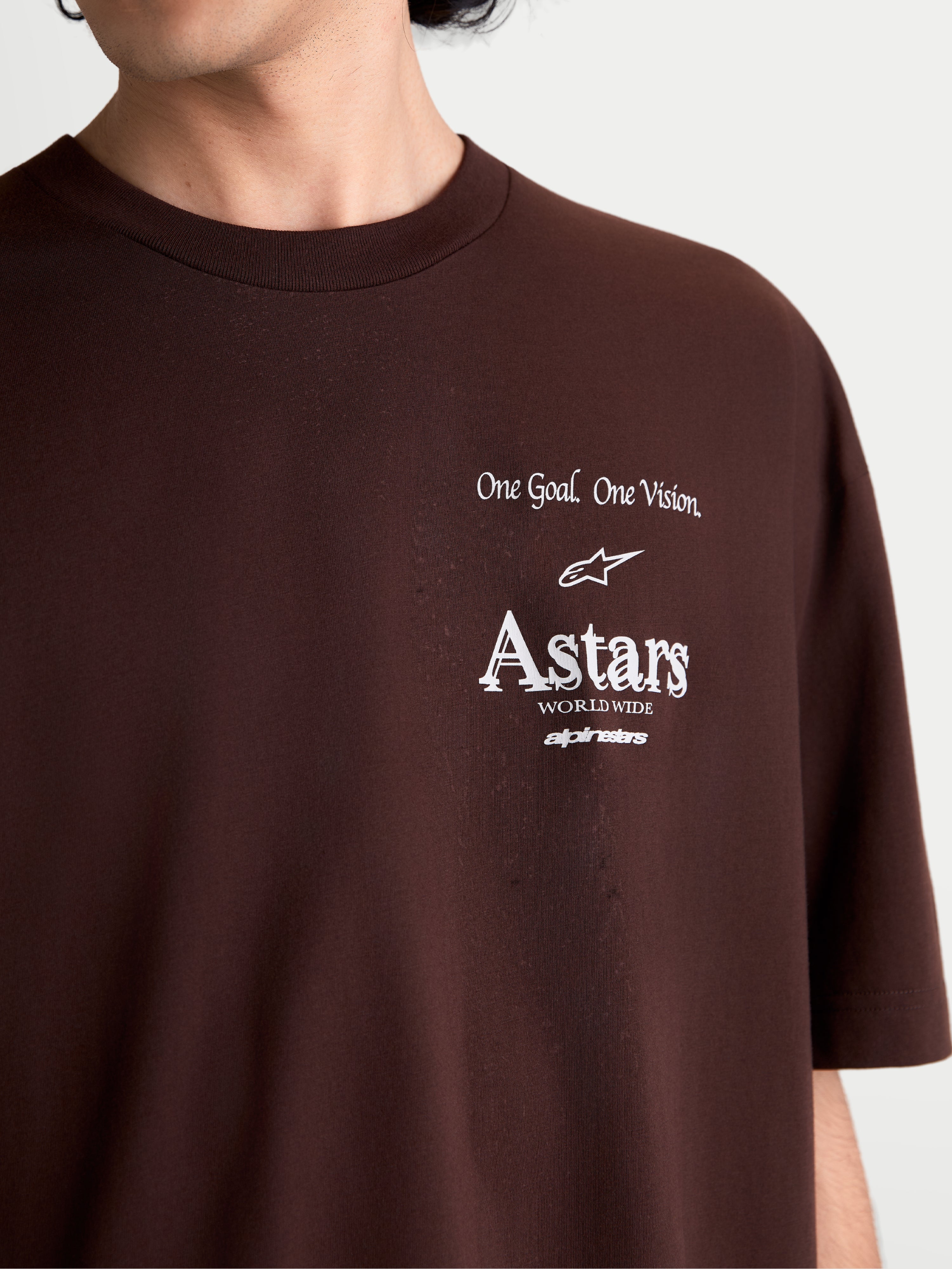 Alpinestars Maglietta Post Oversized CSF, maglietta sportswear a maniche corte, marrone, primo piano della grafica bianca sul petto con logo Astars e motto One Goal. One Vision., in misto cotone e poliestere