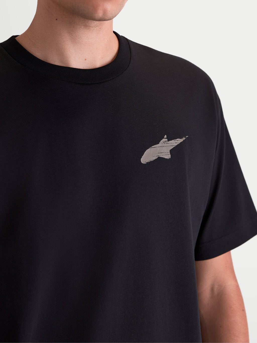 Alpinestars Maglietta Checkback Oversized CSF, maglietta a maniche corte nera, dettaglio del petto con logo Astars grigio e stampa morbida al tatto, stile sportswear casual ispirato al motorsport, misto cotone e poliestere.