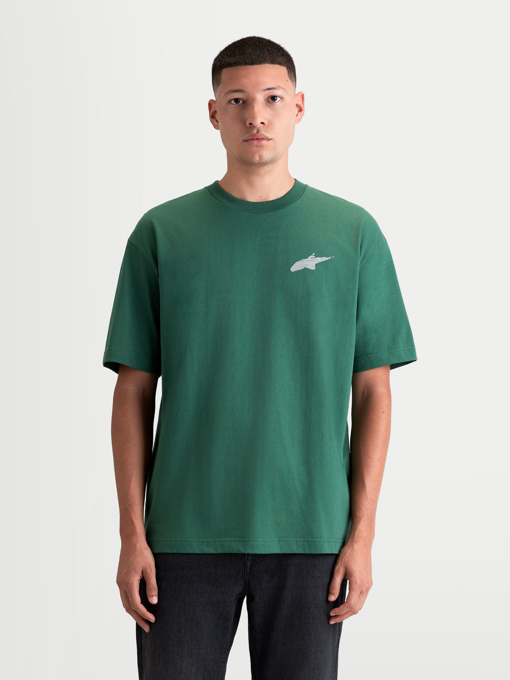 Alpinestars Maglietta Checkback Oversized CSF, maglietta sportswear da uomo a maniche corte, verde e bianca, vista frontale su modello, con vestibilità oversized rilassata e iconico logo Astars sul petto, top casual in misto cotone e poliestere ispirato al motorsport.