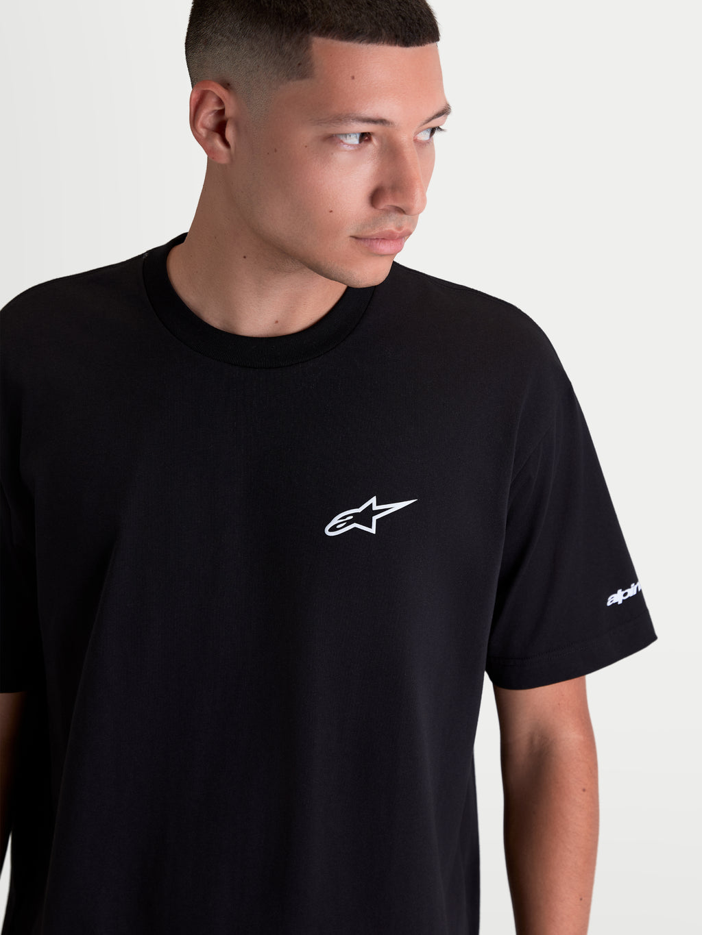 Alpinestars Maglietta Mandate Oversized CSF, maglietta a maniche corte da uomo, nera con logo Astars bianco sul petto e grafica sulla manica, vestibilità oversized rilassata, stile casual sportswear, indossata da un modello.