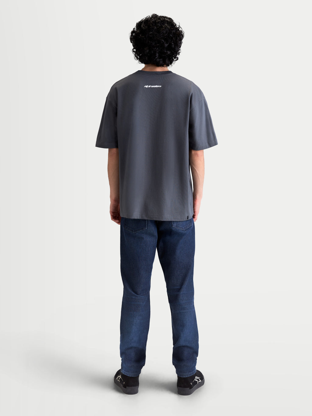 Alpinestars Maglietta Mandate Oversized CSF, maglietta sportswear a maniche corte unisex, grigia, vista posteriore su modello con grafica lettering Alpinestars bianca e vestibilità oversized rilassata, misto cotone-poliestere