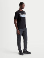 Alpinestars Maglietta Singular CSF, maglietta da uomo a maniche corte, colore nero, grafica Astars curva bianca e stampa One Goal One Vision sul petto, in morbido cotone, indossata da un modello, stile casual ispirato al motorsport
