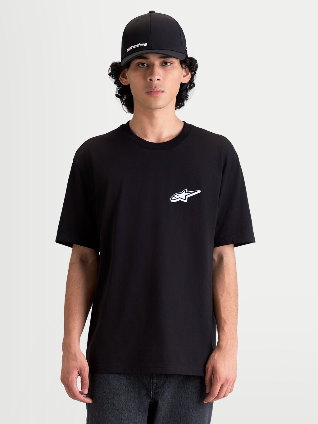 Alpinestars maglietta Meteor CSF, maglietta a maniche corte da uomo, nera con logo Astars bianco sul petto, abbigliamento motorsport casual indossato da un modello.