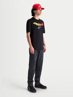 Alpinestars Maglietta Elliptogrit CSF, maglietta da uomo a maniche corte, nera con wordmark Astars giallo e rosso sfumato e logo bianco, abbigliamento sportivo casual.