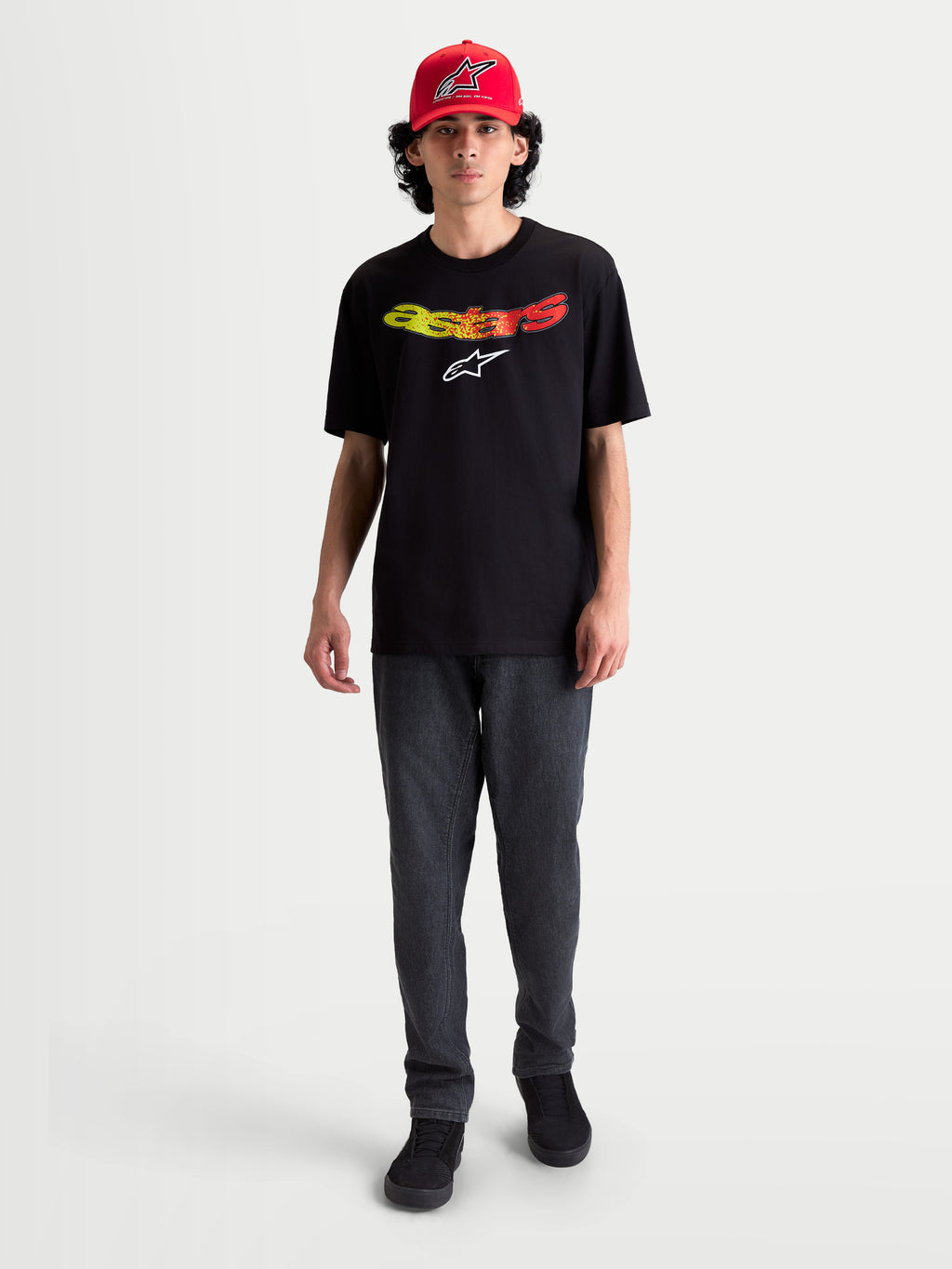 Alpinestars Maglietta Elliptogrit CSF, maglietta da uomo a maniche corte, nera, logo Astars con sfumatura giallo e rosso, abbigliamento casual sportswear, indossata da un modello