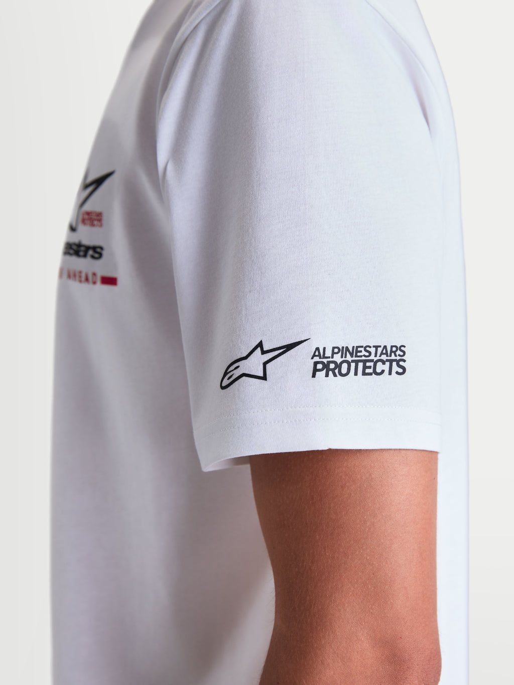 Alpinestars Maglietta P1 CSF, maglietta a maniche corte bianca, dettaglio ravvicinato della grafica con logo e scritta Alpinestars Protects sulla manica, stile sportswear casual
