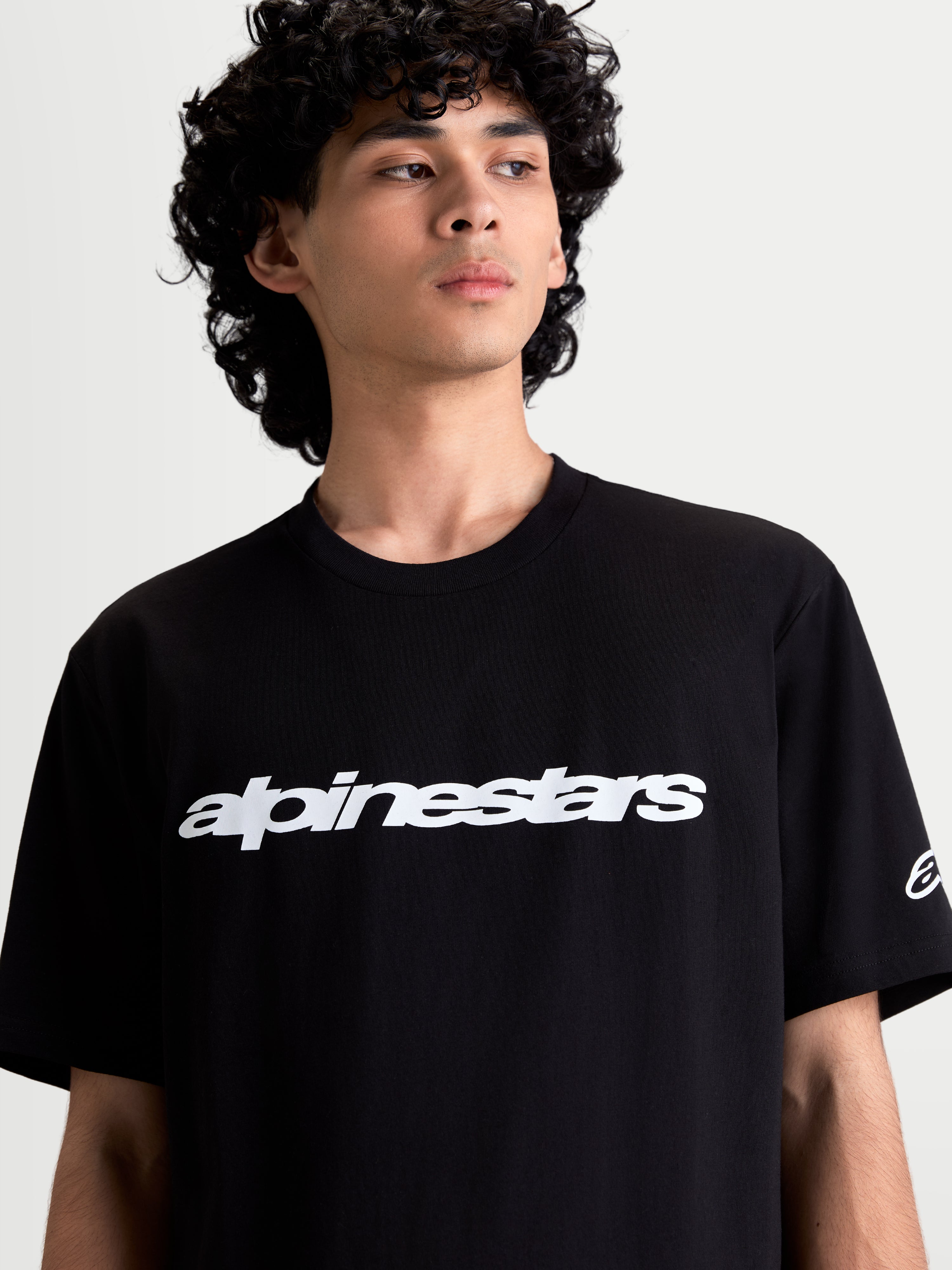 Alpinestars Maglietta Race Wordmark CSF, maglietta sportswear casual per uomo, nera e bianca, con grafica wordmark frontale e logo Ageless sulla manica, in misto cotone e poliestere, indossata da un modello
