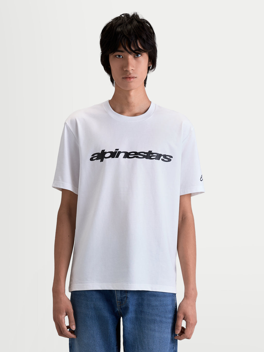 Alpinestars Maglietta Race Wordmark CSF, maglietta a maniche corte da uomo, bianca e nera, con wordmark frontale e logo sulla manica, vista frontale su modello, stile sportswear casual