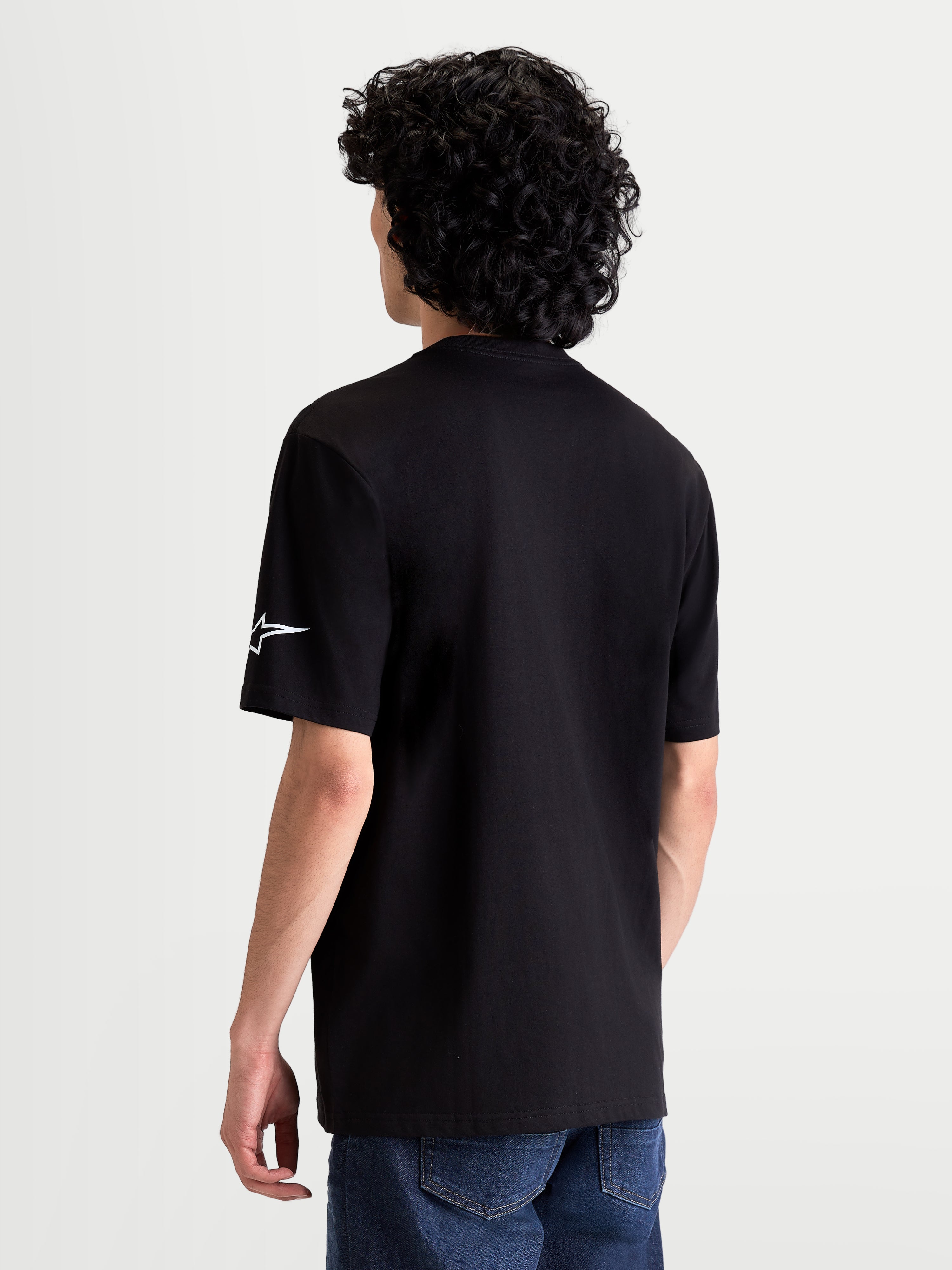 Alpinestars maglietta Race Wordmark CSF, maglietta a maniche corte, nera con logo Ageless bianco sulla manica, vista posteriore su modello, abbigliamento sportswear casual ispirato al motorsport