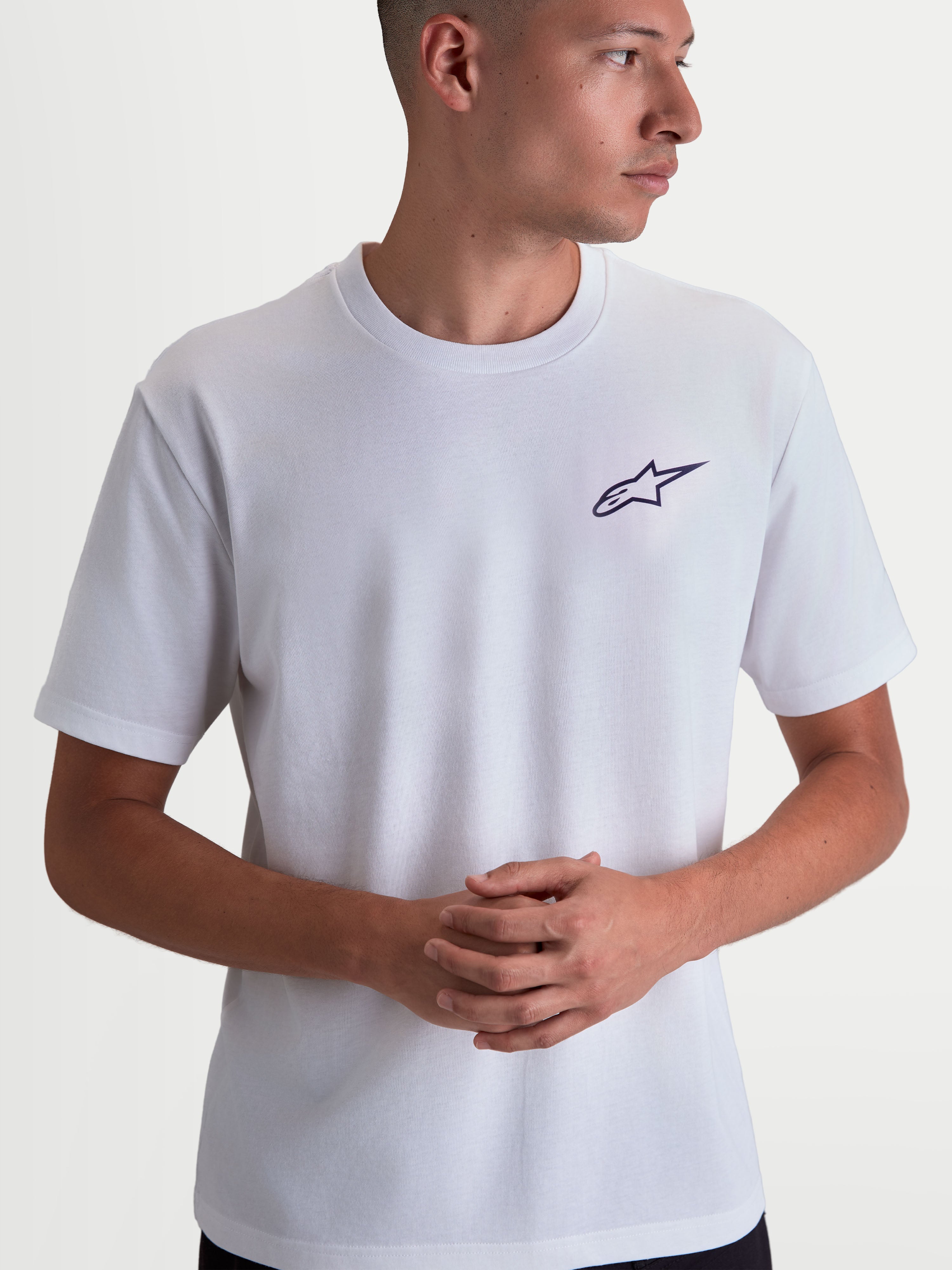 Alpinestars Combo Back CSF Tee, maglietta a maniche corte da uomo, bianca con piccolo logo Astars nero stampato sul petto, stile sportswear casual ispirato al motorsport, costruzione in misto cotone e poliestere, indossata da un modello.