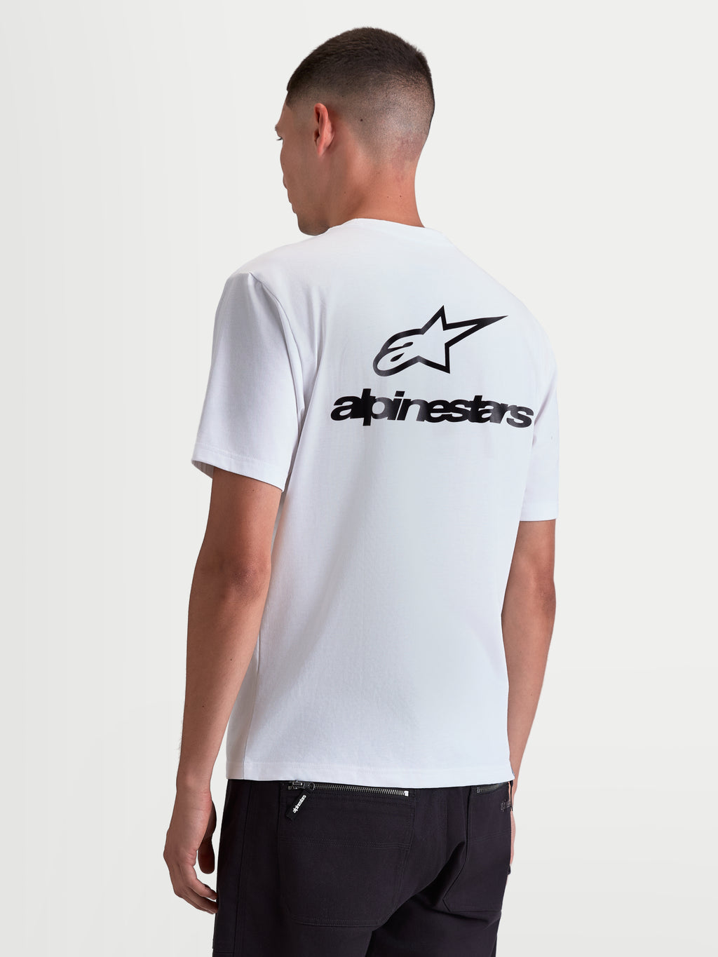 Alpinestars Maglietta Combo Back CSF, maglietta a maniche corte da uomo, bianca con grande grafica logo Astars nera sulla schiena, vista posteriore su modello, stile sportswear casual ispirato al motorsport