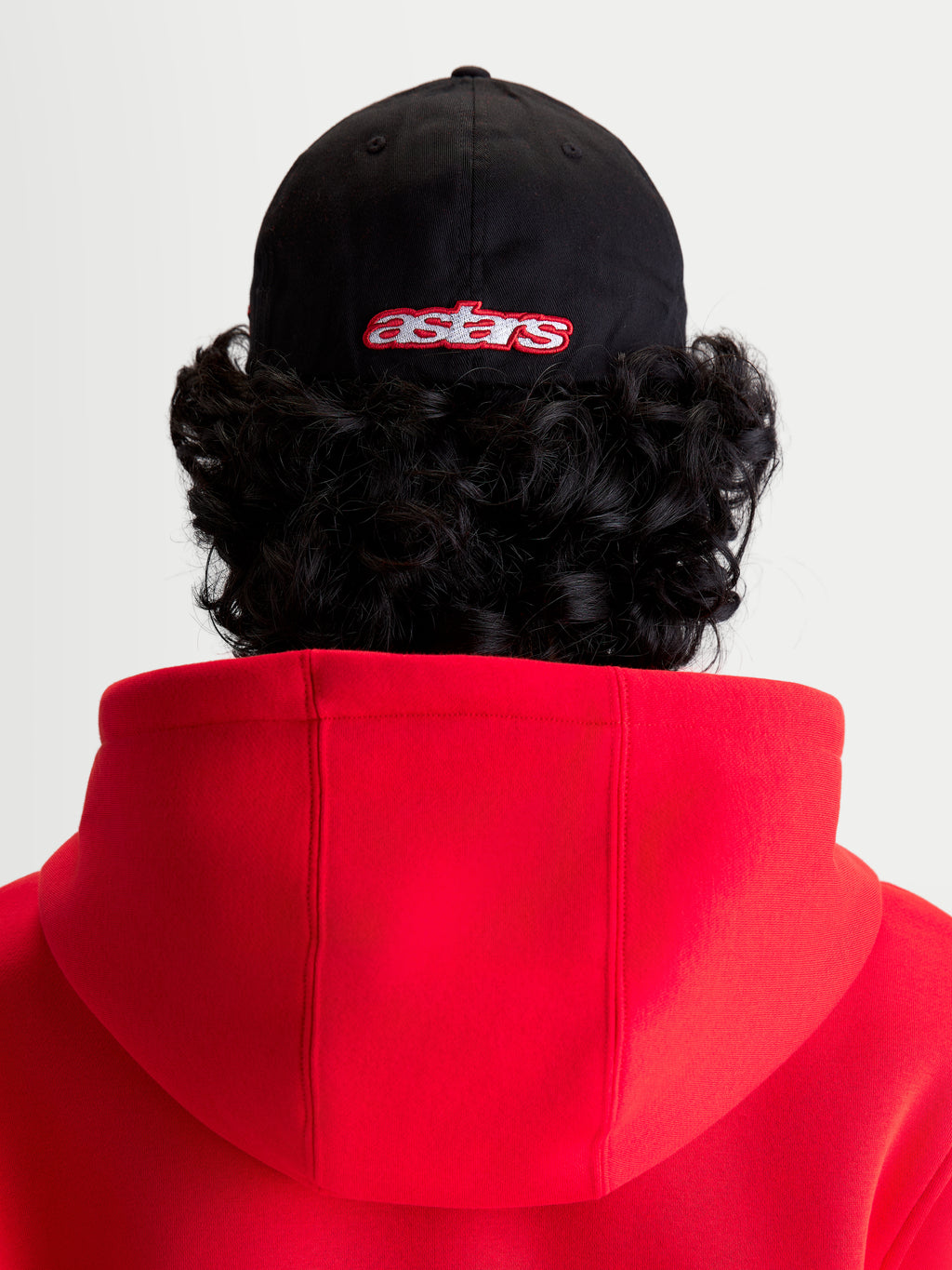 Alpinestars Cappello Lineout, cappello da baseball, nero e rosso, vista posteriore su modello con logo astars ricamato, corona strutturata, costruzione in tessuto twill.