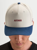 Alpinestars Cappello County Canvas, cappello sportswear in sabbia e blu, visiera curva, corona strutturata, con ricamo Astars frontale indossato da un modello