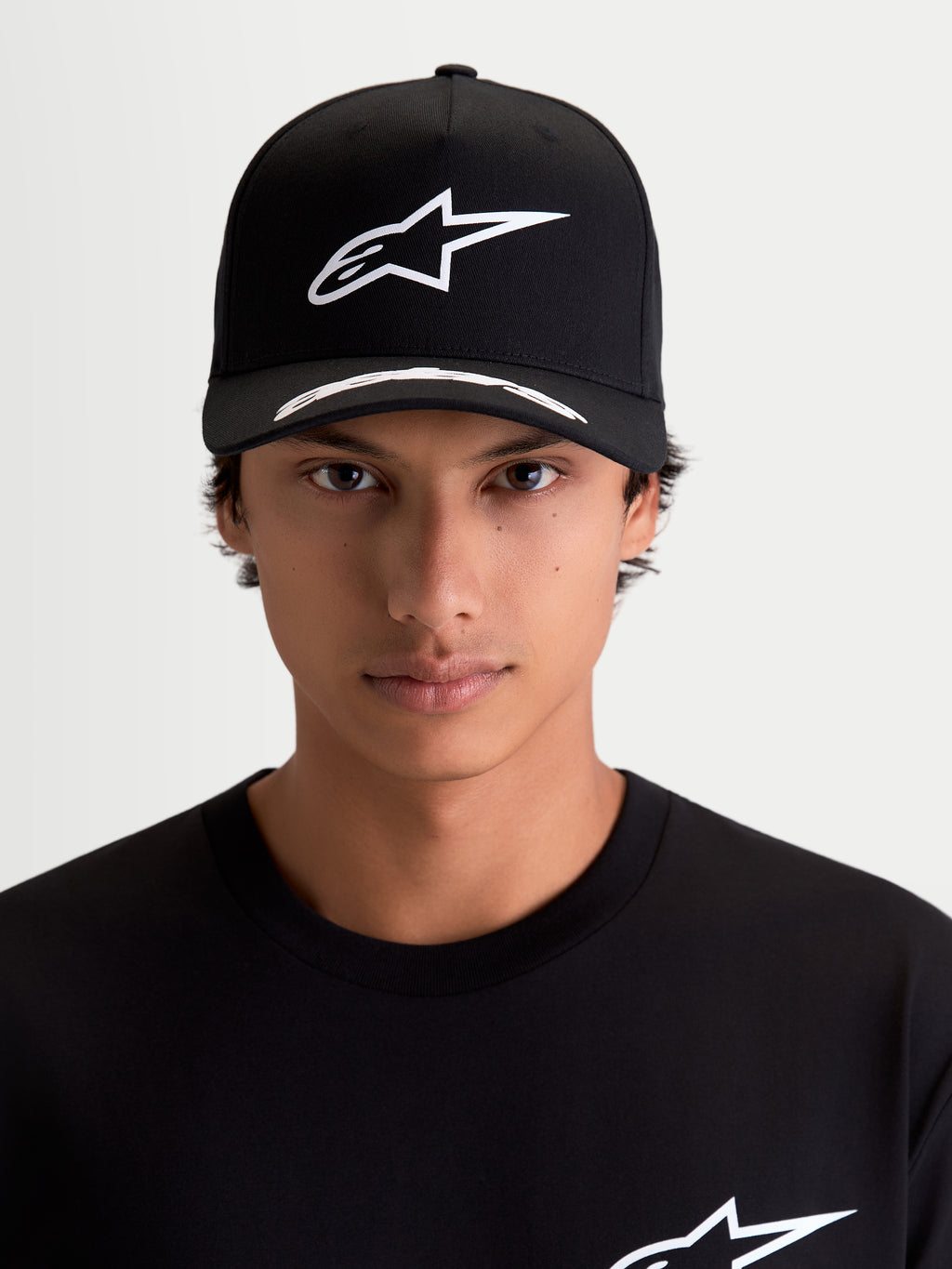 Alpinestars Cappello Arclight, cappello sportswear motorsport, nero e bianco, logo Astars bianco in puff-print sulla corona strutturata e visiera curva con dettagli, in tessuto twill, vista frontale su modello