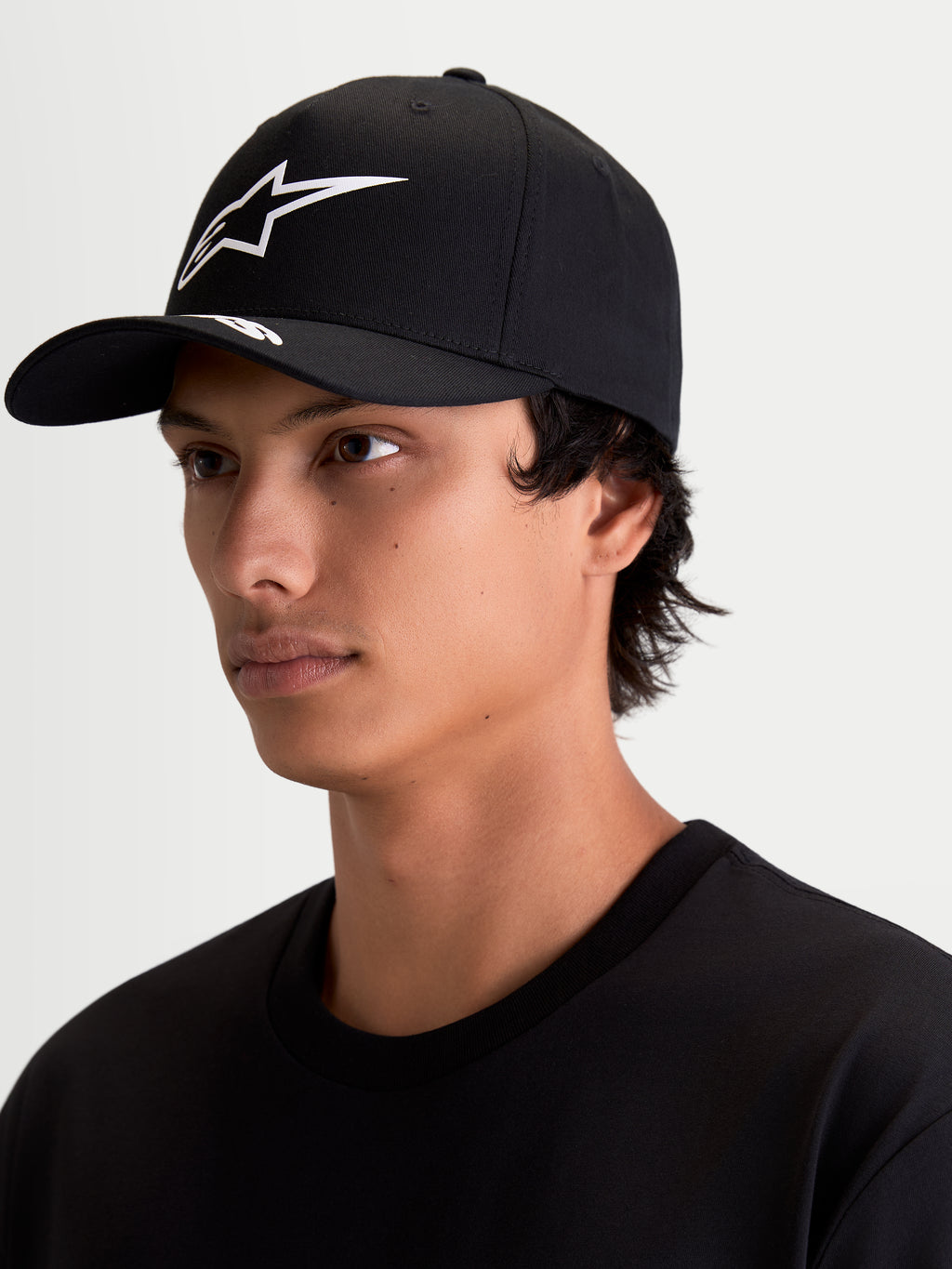 Alpinestars Cappello Arclight, cappello da baseball sportswear unisex, nero e bianco, visiera curva, corona strutturata e logo Astars bianco in puff-print testurizzato, indossato da un modello