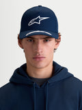 Alpinestars cappello Arclight, cappello sportswear con visiera curva, blu navy e bianco, vista frontale su modello, corona strutturata, logo Astars in rilievo puff print e twill di cotone premium
