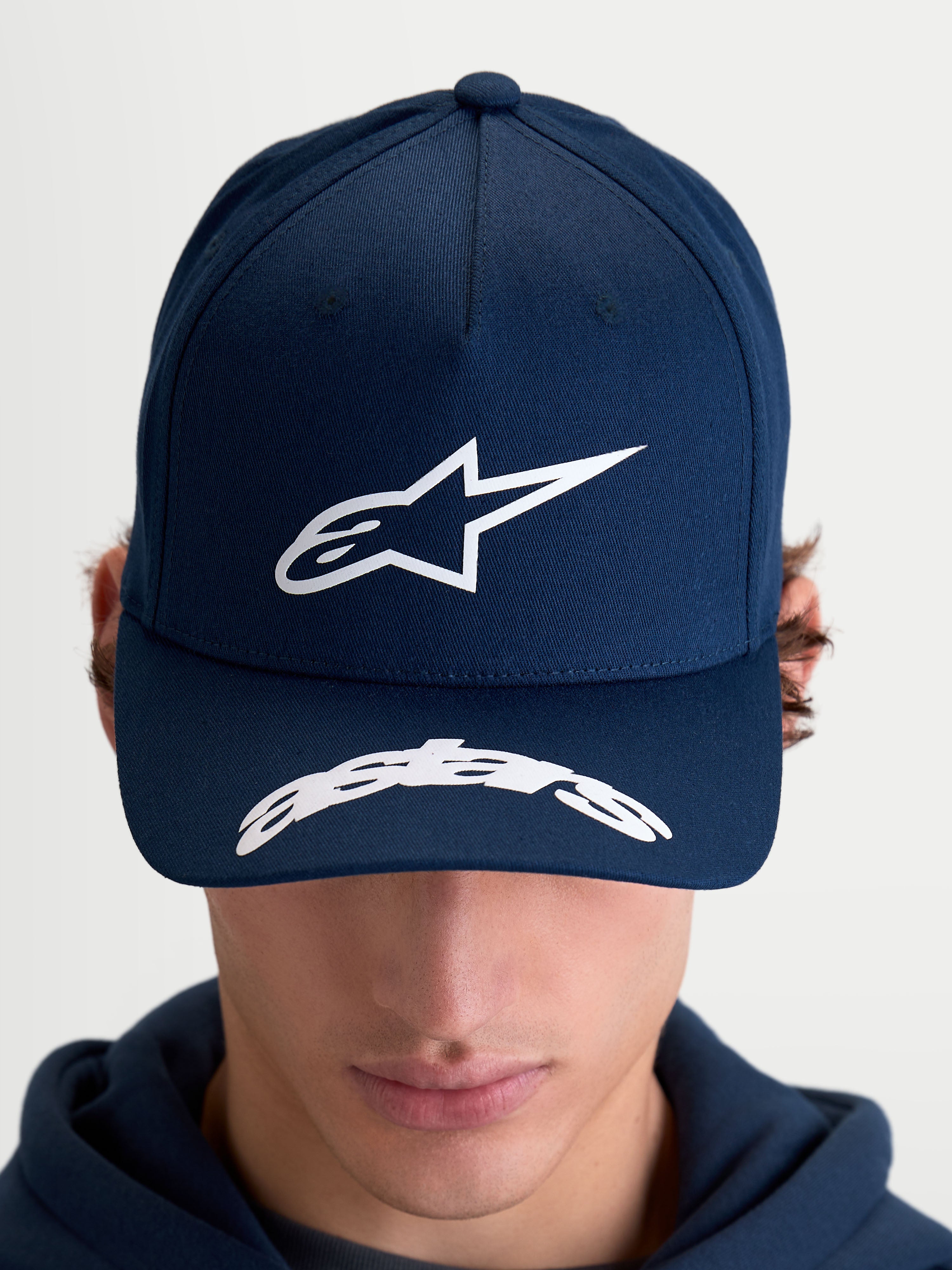Alpinestars cappello Arclight, cappello sportswear da baseball unisex, blu navy e bianco, corona strutturata con logo Astars in rilievo e visiera curva con scritta, in twill di cotone, vista frontale indossata.