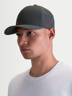 Alpinestars Cappello Points, cappello sportswear con visiera curva indossato da un modello, grigio scuro con logo rosso, in nylon tactel leggero, vestibilità flex-back per il massimo comfort quotidiano