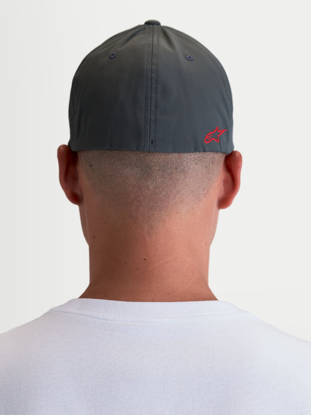 Alpinestars Cappello Points, cappello sportswear unisex, grigio scuro e rosso, vista posteriore su modello con logo Astars HD rosso, in nylon tactel leggero e vestibilità flex-back