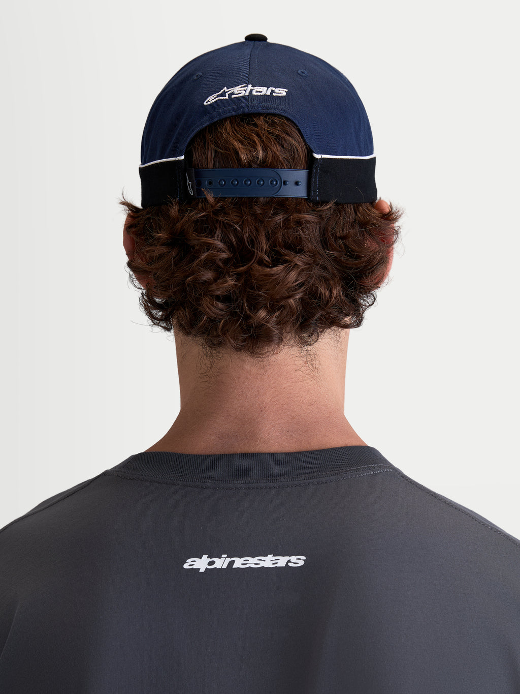 Alpinestars Cappello 500 Snapback, cappello sportswear ispirato al motorsport, blu navy e nero, in twill di cotone con chiusura snapback regolabile e logo Astars ricamato, vista posteriore su modello.