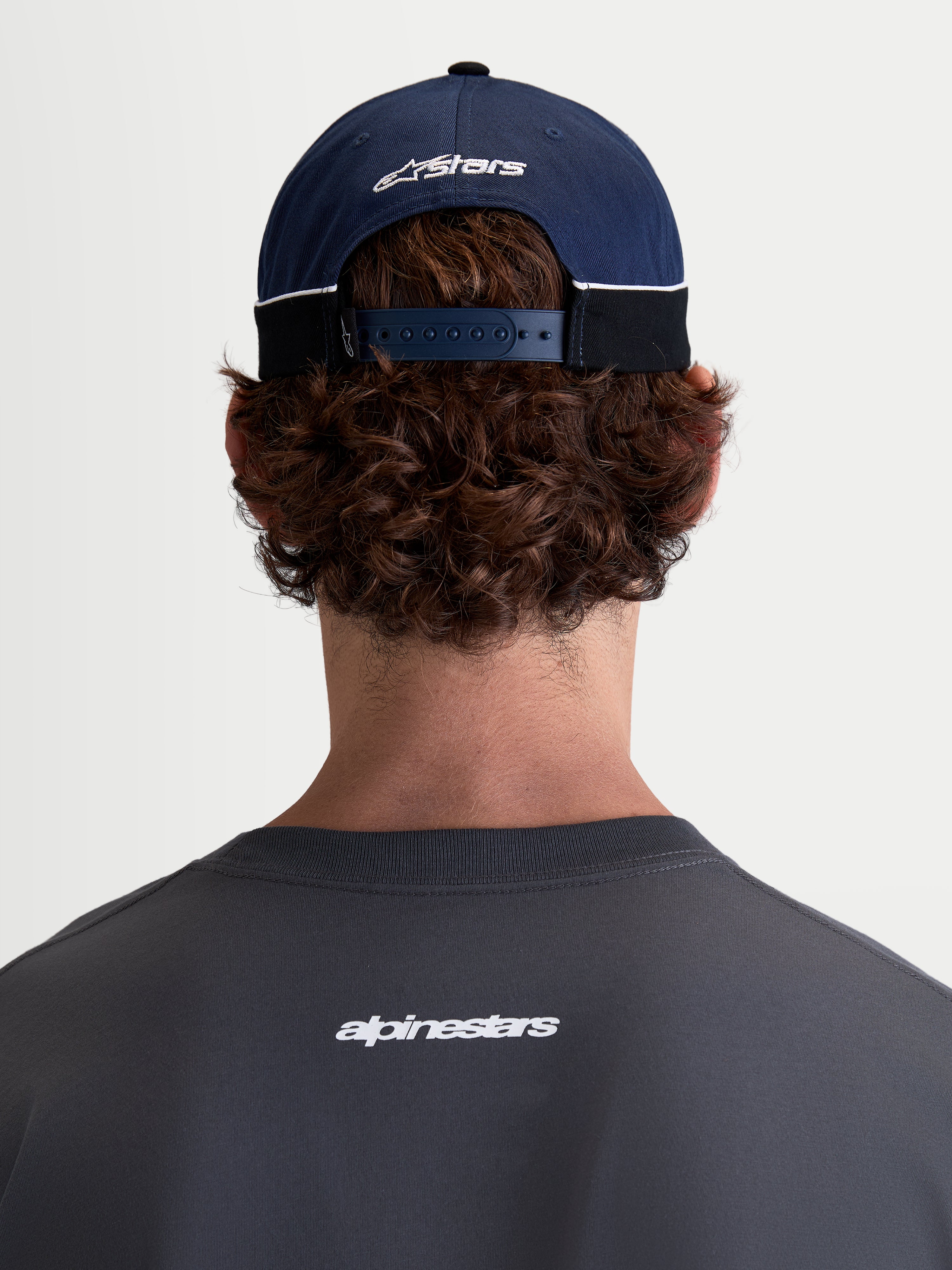 Alpinestars Cappello 500 Snapback, cappello sportswear ispirato al motorsport, blu navy e nero, in twill di cotone con chiusura snapback regolabile e logo Astars ricamato, vista posteriore su modello.
