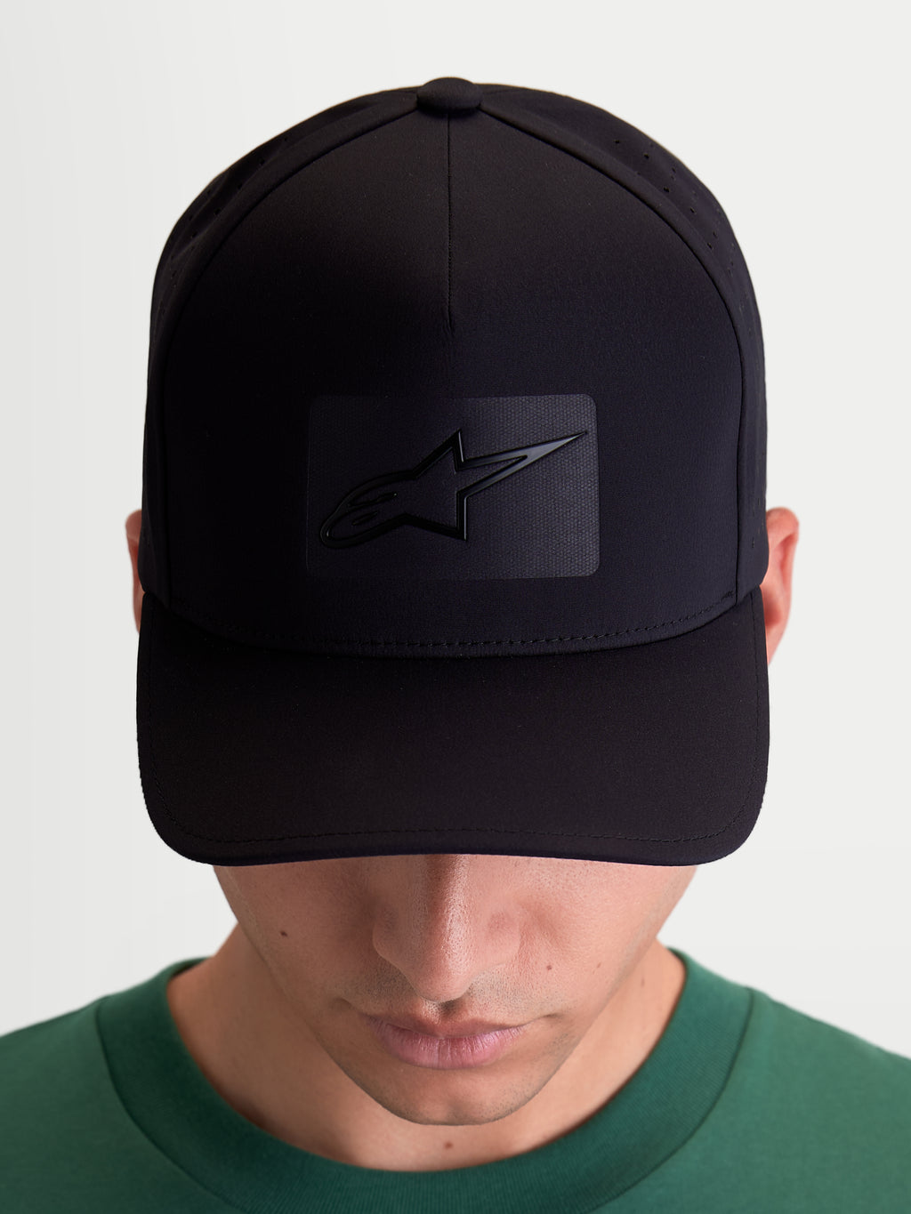 Alpinestars Cappello Algo Perf Adjustable, cappello da baseball sportswear unisex, nero, in tessuto tecnico con perforazioni laterali, visiera curva e corona strutturata, vista frontale su modello con logo Astars saldato sonicamente.