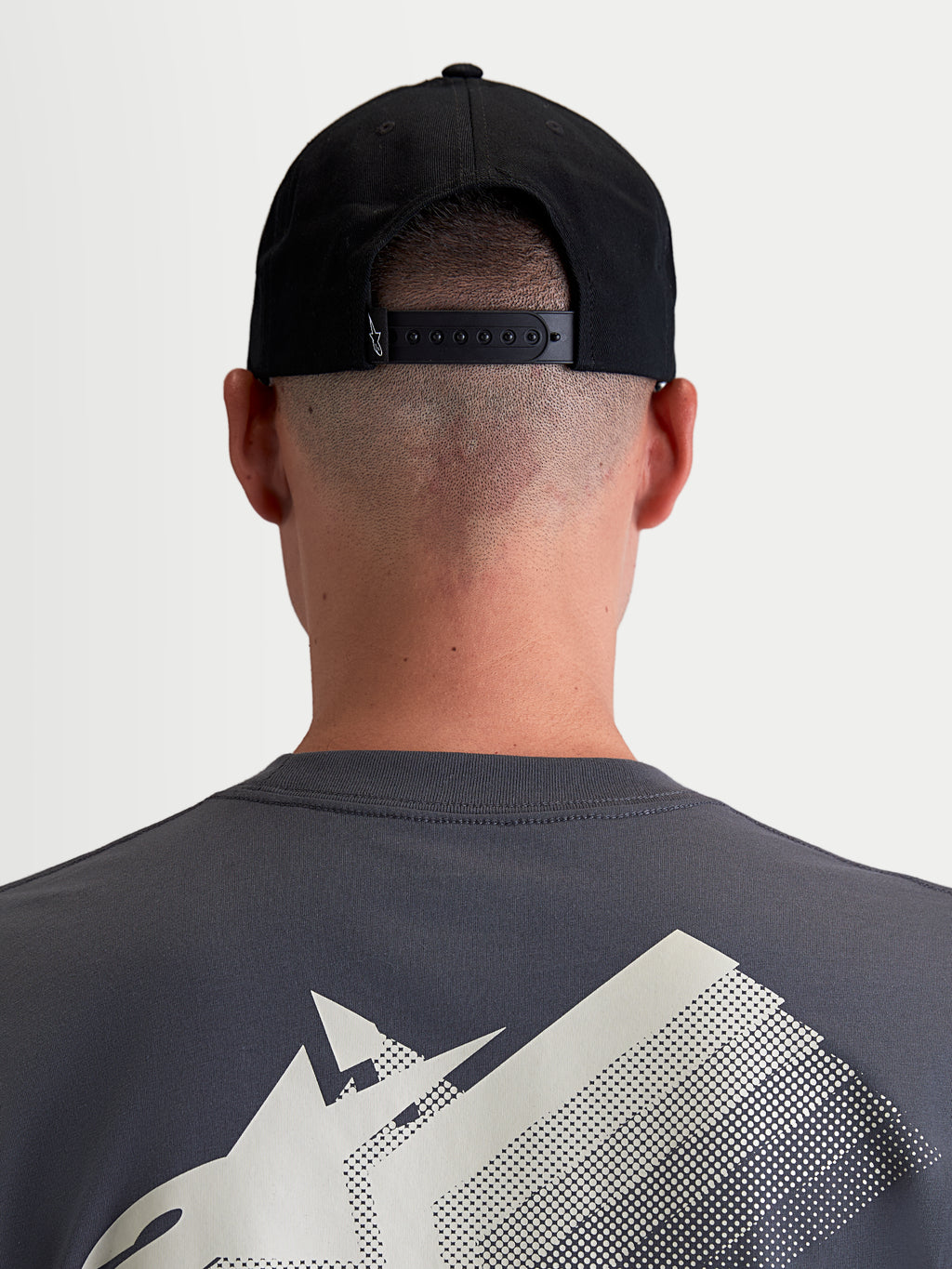 Alpinestars Cappello Combo Logo Snapback, cappello sportswear unisex, nero, twill di cotone resistente, vista posteriore su modello con chiusura snapback regolabile e piccolo dettaglio logo bianco.