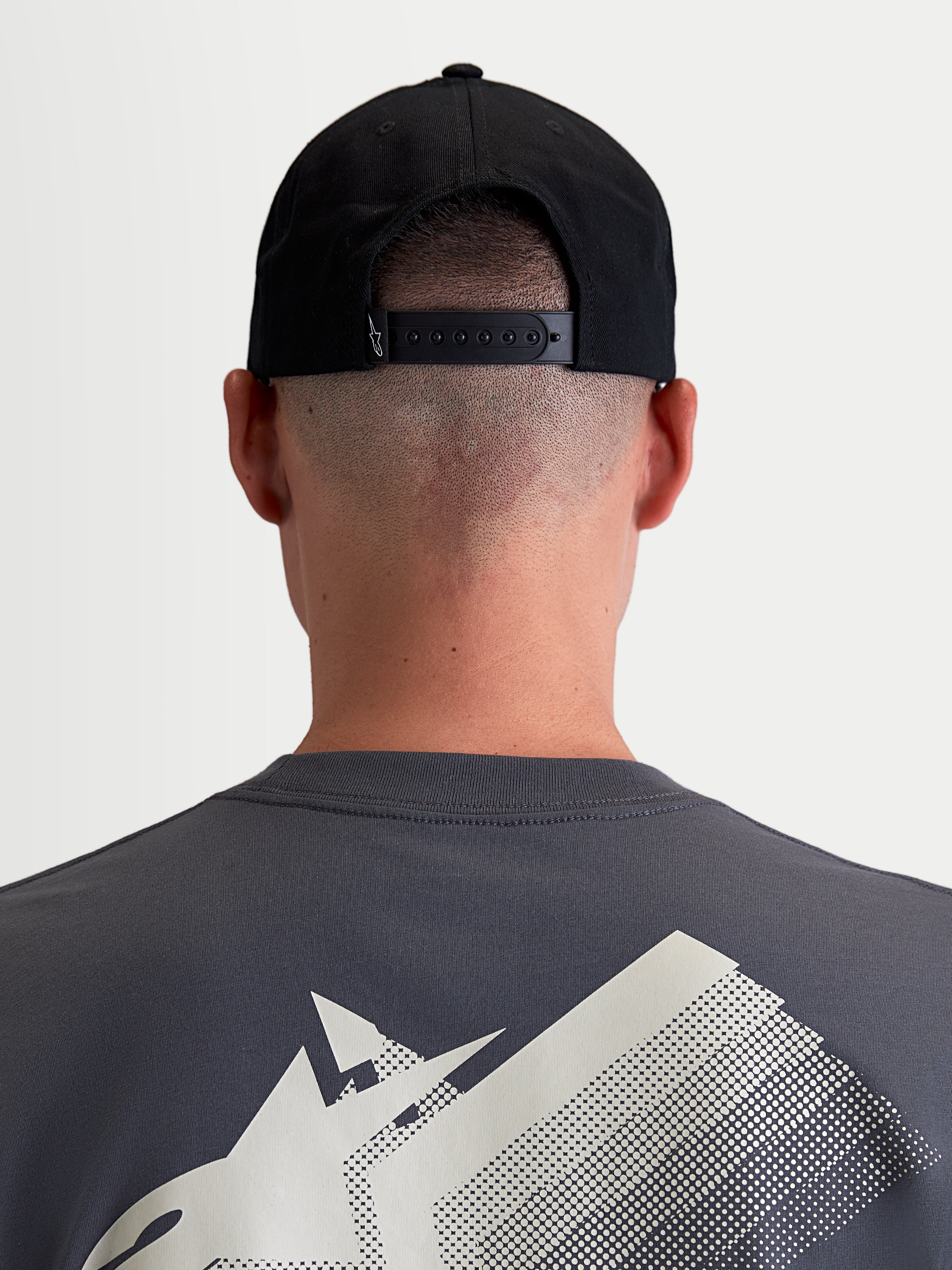 Alpinestars Cappello Combo Logo Snapback, cappello sportswear unisex, nero, twill di cotone resistente, vista posteriore su modello con chiusura snapback regolabile e piccolo dettaglio logo bianco.
