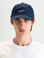 Alpinestars Cappello Dylan Dad, cappello sportswear casual in blu scuro con ricamo del logo Astars bianco, visiera curva e corona bassa non strutturato indossato da un modello