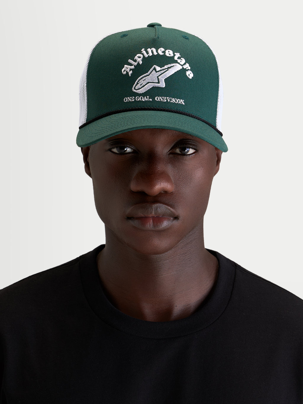 Alpinestars Cappello Baron, cappello trucker casual verde e bianco, visiera curva con corona strutturata e retro in rete, indossato da un modello