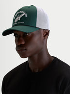 Alpinestars Cappello Baron, cappellino trucker casual sportswear, verde e bianco, con visiera curva, corona strutturata in twill, retro in rete traspirante e logo frontale ricamato, indossato da un modello