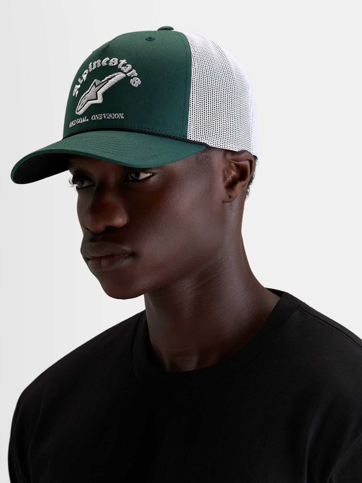 Alpinestars Cappello Baron, cappellino trucker casual sportswear, verde e bianco, con visiera curva, corona strutturata in twill, retro in rete traspirante e logo frontale ricamato, indossato da un modello