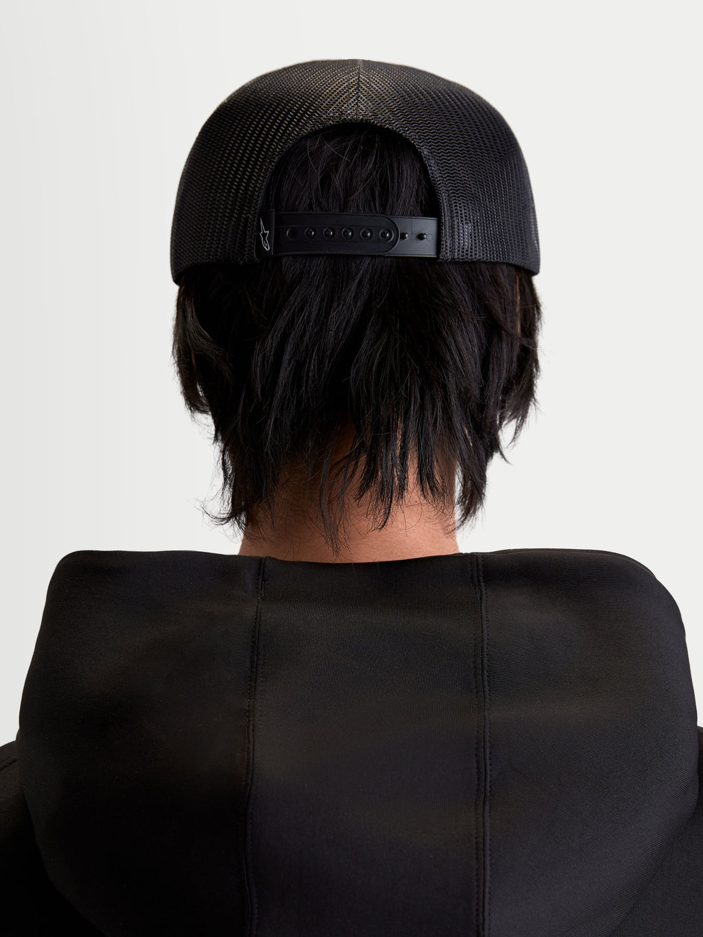 Alpinestars Cappello Gravel, cappello trucker sportswear unisex, nero, vista posteriore su modello che mostra il retro in rete traspirante e la chiusura snapback regolabile
