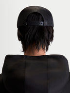 Alpinestars Cappello Gravel, cappello trucker sportswear unisex, nero, vista posteriore su modello che mostra il retro in rete traspirante e la chiusura snapback regolabile