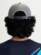 Alpinestars Cappello Gravel Trucker, cappello trucker sportswear, vista posteriore su modello con retro in rete grigia traspirante e chiusura snapback regolabile nera per una vestibilità personalizzata.