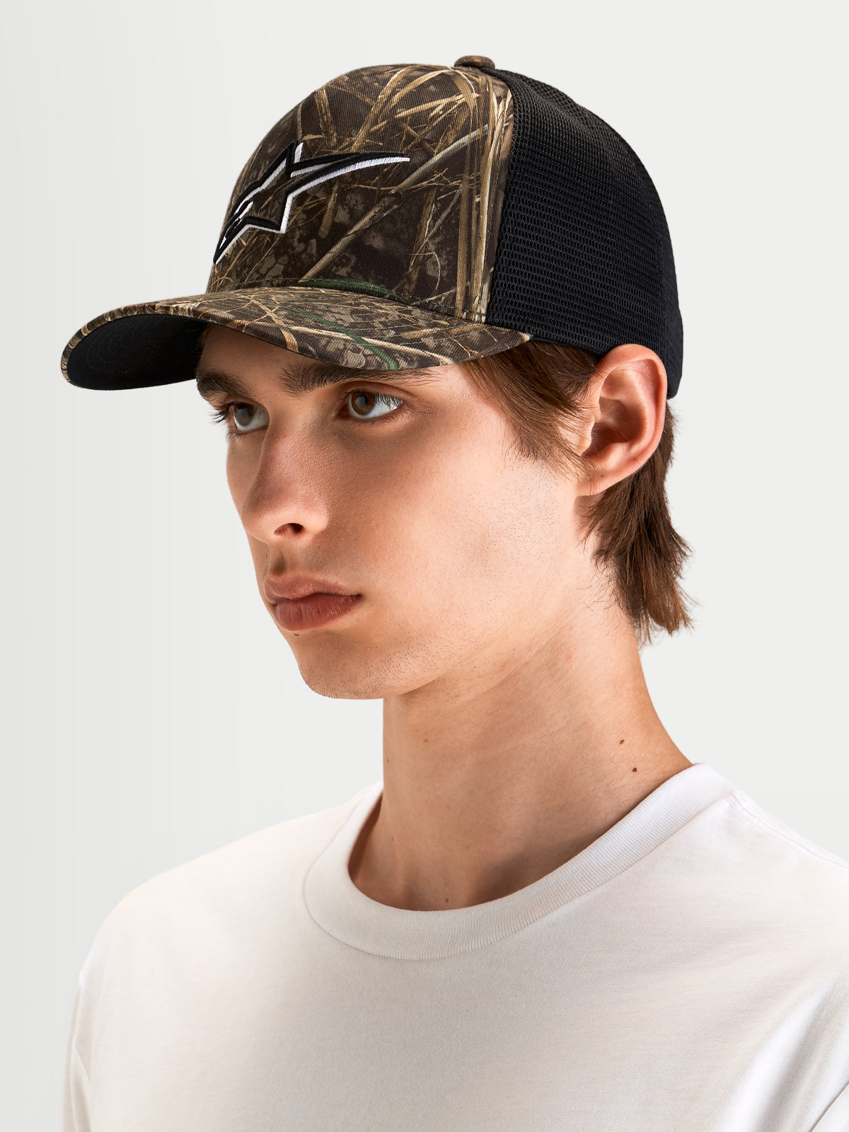 Alpinestars Cappello Thicket Realtree Trucker, cappello trucker sportswear mimetico Realtree e nero, visiera curva, corona strutturata e logo Astars ricamato in 3D, indossato da un modello
