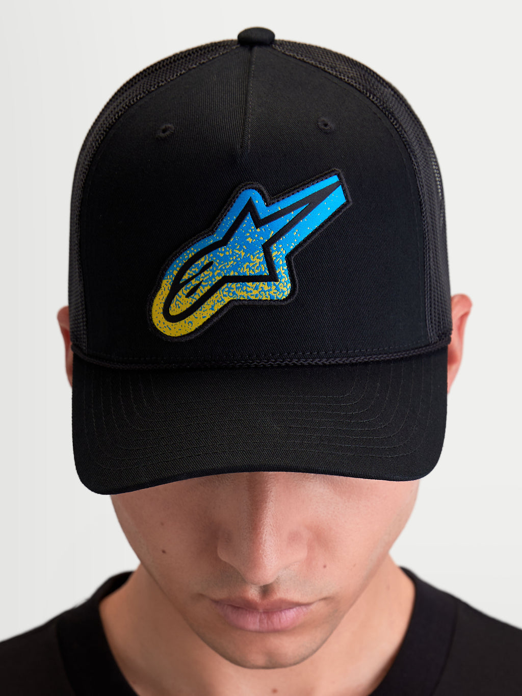 Alpinestars Cappello Meteorite, cappello sportswear con retro in rete, nero e blu con logo Astars a trama ghiaia, corona strutturata e visiera curva, indossato da un modello