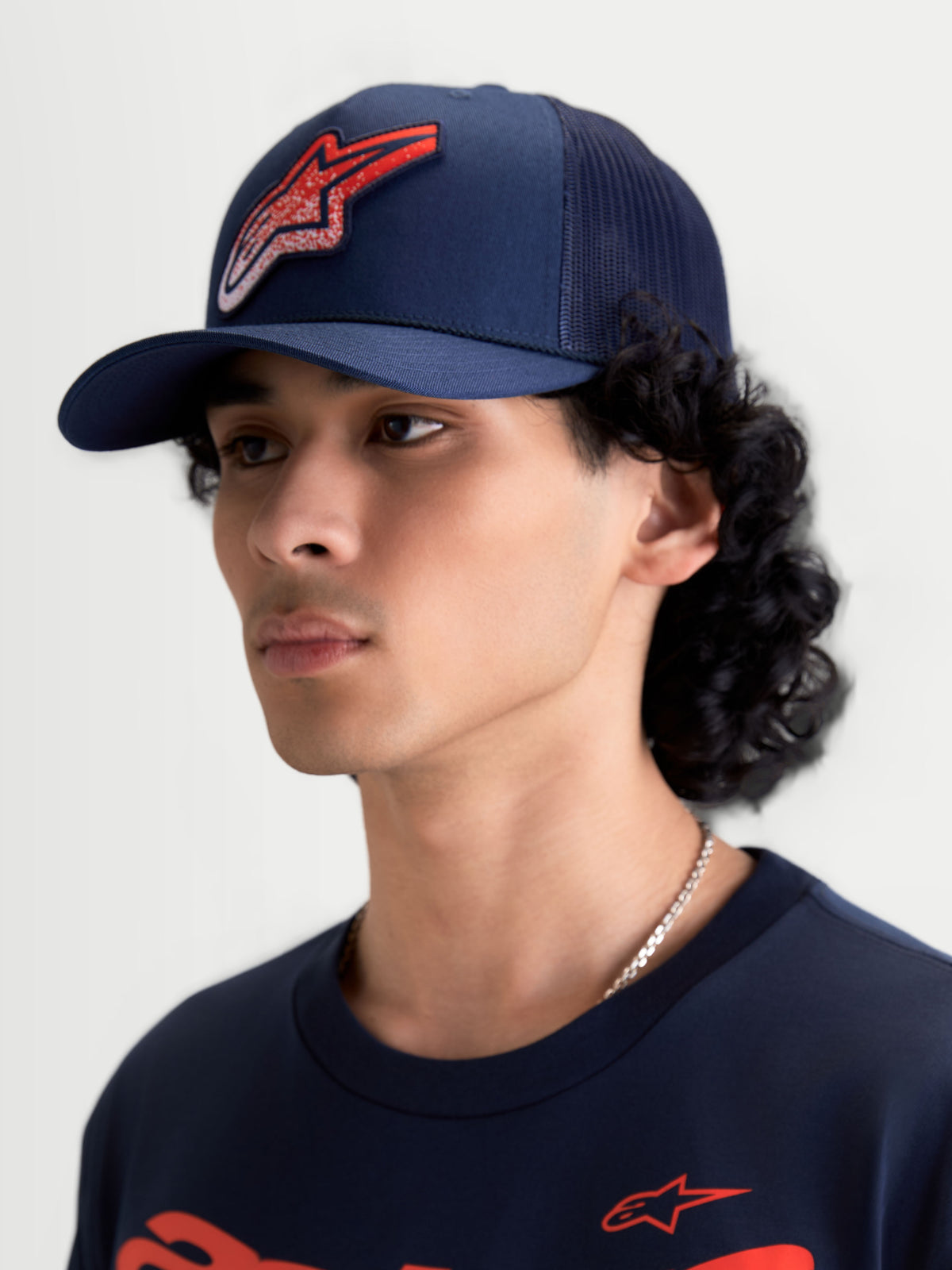 Alpinestars Cappello Meteorite Trucker, cappello stile trucker blu navy con logo Astars rosso a trama ghiaia, corona strutturata e visiera curva, retro in rete, vista su modello, sportswear