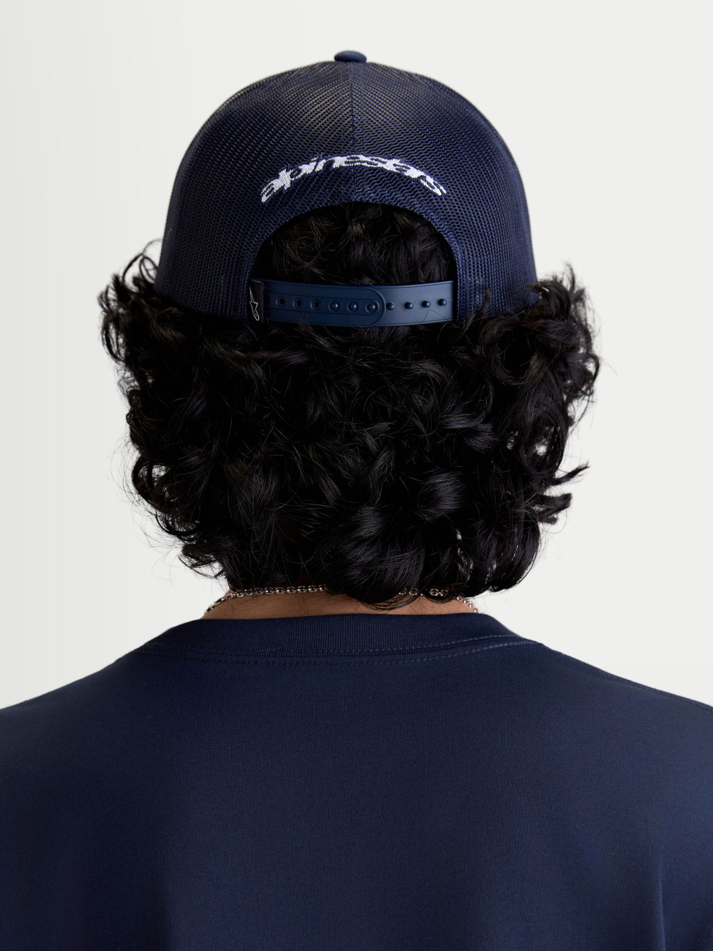 Alpinestars cappello Meteorite Trucker, cappello casual sportswear, vista posteriore su modello, blu, retro in rete di poliestere e chiusura snapback regolabile con logo bianco ricamato
