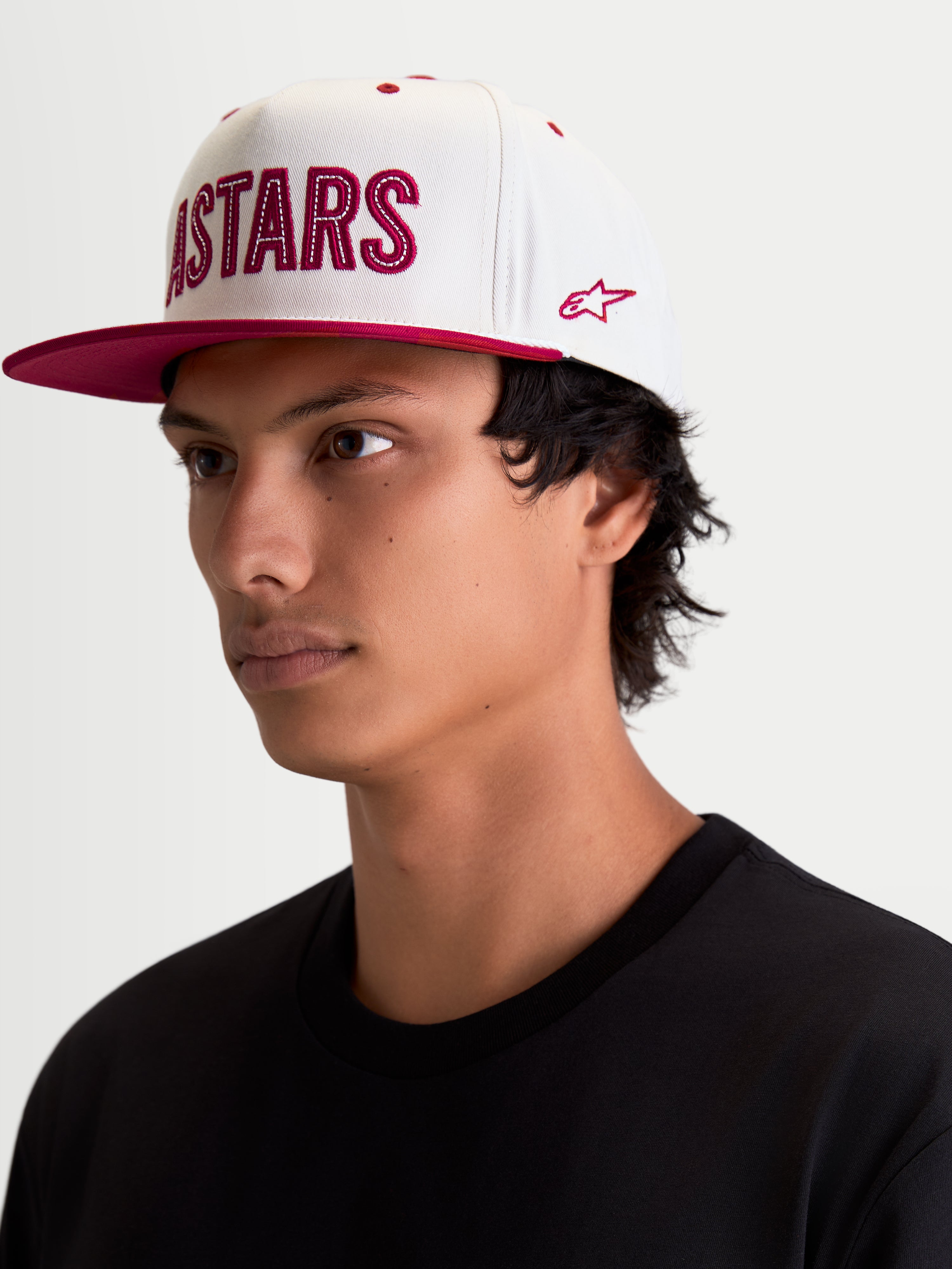 Alpinestars Cappello Stadium Snapback, cappello sportswear lifestyle, bianco e rosso, visiera piatta, corona strutturata, logo Astars applicato frontalmente con cuciture a contrasto e ricamo laterale, visto su modello.