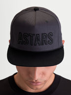 Alpinestars Cappello Stadium Snapback, cappello sportswear unisex ispirato al motorsport, grigio scuro e nero, con visiera piatta, corona strutturata e logo ASTARS ricamato, in twill di cotone, indossato da un modello.