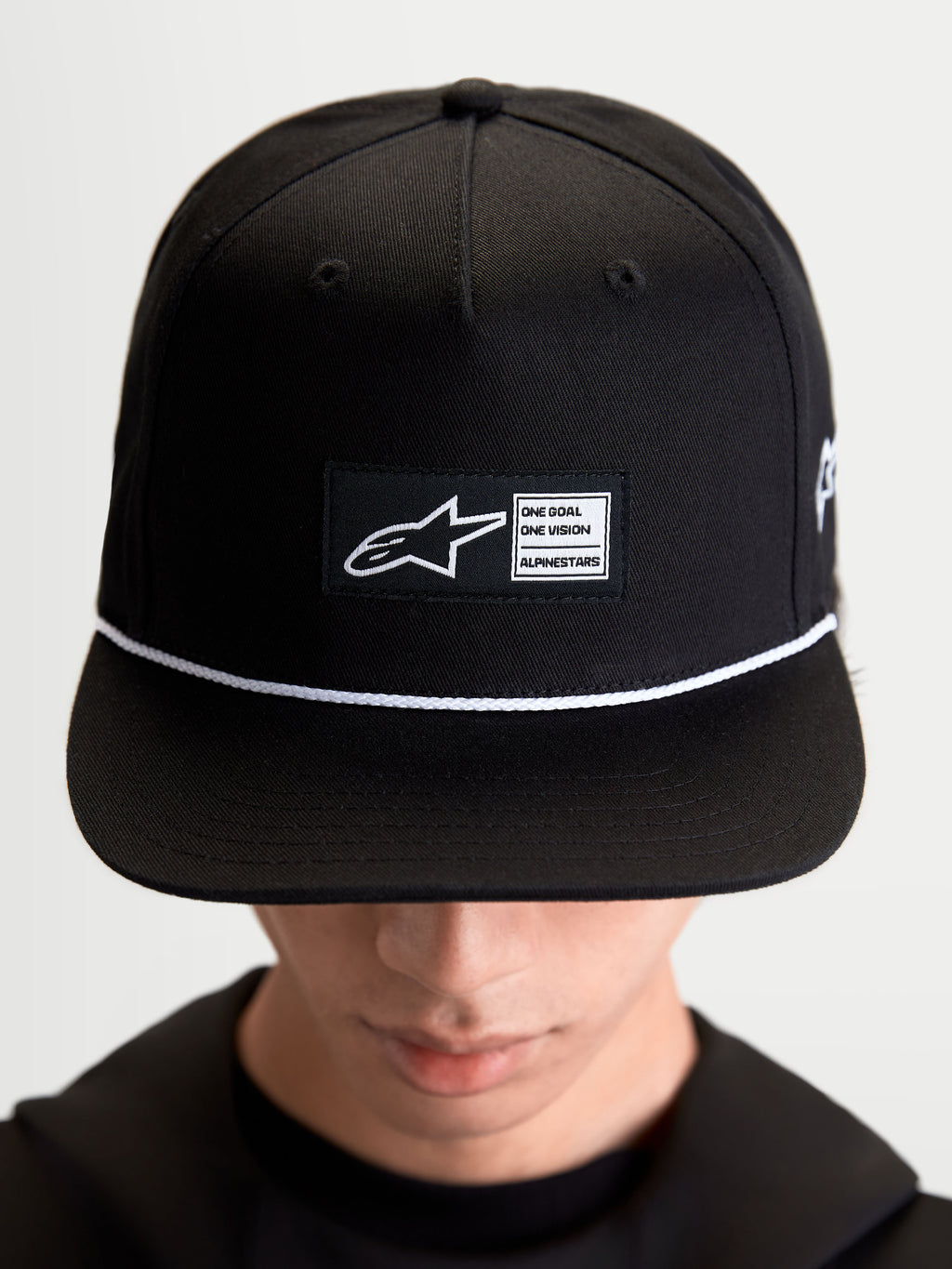 Alpinestars Cappello Label Snapback, cappello lifestyle sportswear unisex, nero e bianco, in twill di cotone, corona strutturata con visiera piatta, cordoncino e patch frontale con logo, indossato