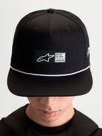 Alpinestars Cappello Label Snapback, cappello lifestyle sportswear unisex, nero e bianco, in twill di cotone, corona strutturata con visiera piatta, cordoncino e patch frontale con logo, indossato