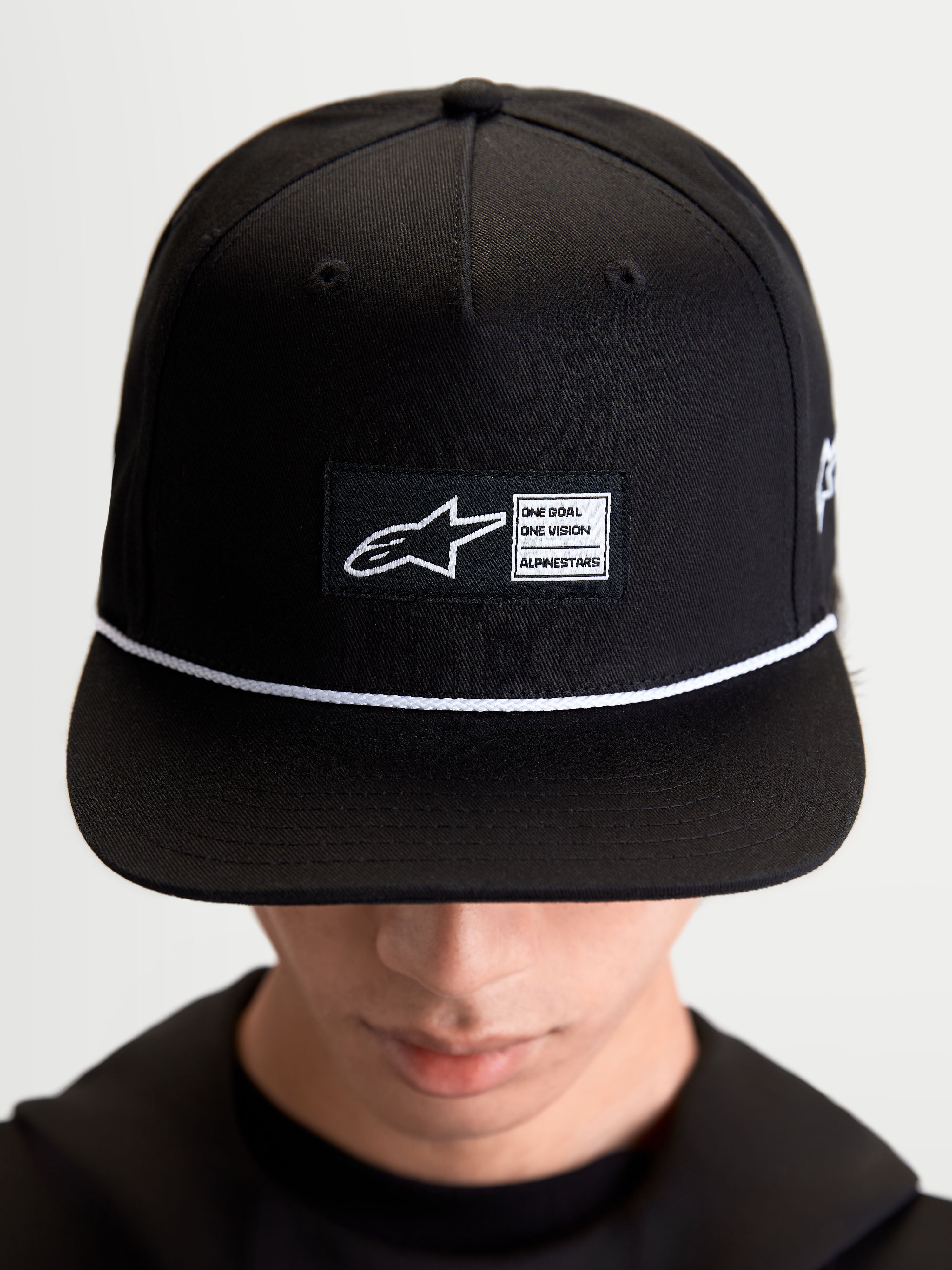 Alpinestars Cappello Label Snapback, cappello lifestyle sportswear unisex, nero e bianco, in twill di cotone, corona strutturata con visiera piatta, cordoncino e patch frontale con logo, indossato