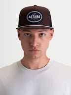 Alpinestars Cappello Hotlink, cappello marrone e nero stile motorsport, corona strutturata, visiera piatta con dettaglio corda bianca e patch logo Astars Worldwide tessuta, mostrato su modello