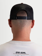 Alpinestars Cappello Hotlink, cappello trucker sportswear unisex, marrone e nero, vista posteriore indossata con chiusura snapback regolabile, pannelli posteriori in mesh traspirante e dettaglio del logo.
