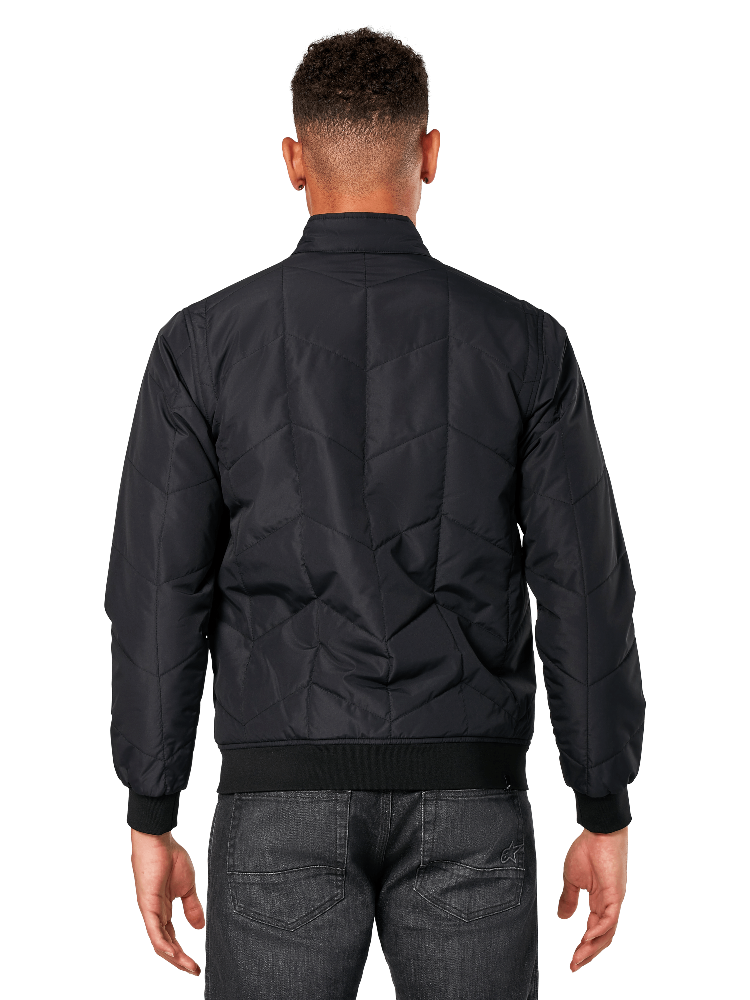Giacca Alpinestars Precedent, nero, vista posteriore su modello, con iconico motivo trapuntato angolato, polsini e orlo a coste, design motorsport trapuntato ispirato alla F1