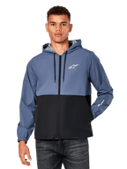 Alpinestars Speeder Windbreaker Jacket, giacca a vento casual con cappuccio, design bicolore blu ardesia e nero, logo Astar bianco sul petto e marchio sulla manica, zip frontale con cappuccio a cordino, fodera leggera in rete