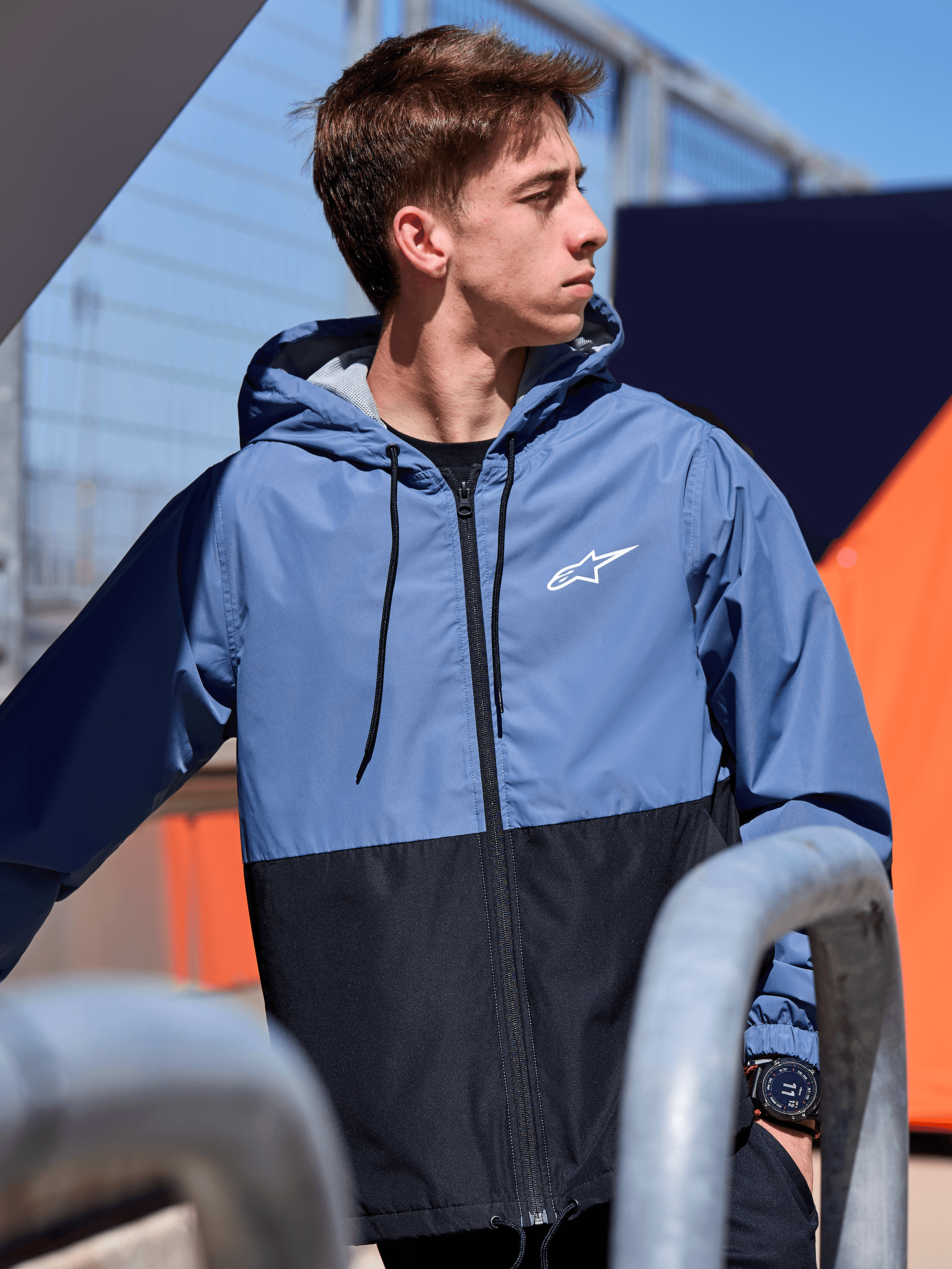 Giacca a vento Alpinestars Speeder, giacca a vento leggera con cappuccio, design color-block blu e nero, logo Alpinestars bianco sul petto, fodera in rete e cappuccio con cordino, streetwear casual ispirato al motorsport